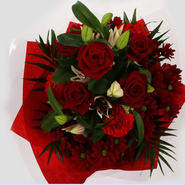 Red Roses & Lilly BouquetRed Roses & Lilly Bouquet, A beautiful Elegant bouquet featuring Red Roses, Pink Lillies, Red Chrysanthemums, Red Dianthus and Stylish Palm leaves with Foliage, perfect. Expertly created by our florists Beautifully wrapped and tie