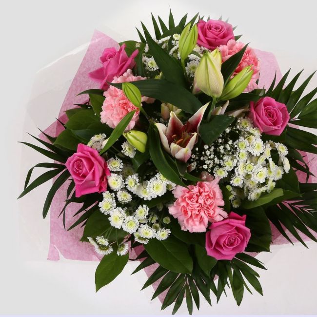 Strawberry Sundae BouquetStrawberry Sundae Bouquet, An endearing classic Bouquet, Lilies in soft pinks, White Santini, with Pink Roses, large exquisite headed Dianthus, Pink Roses are complemented by delicate Gypsophila, luxurious sophisticated hand-tied