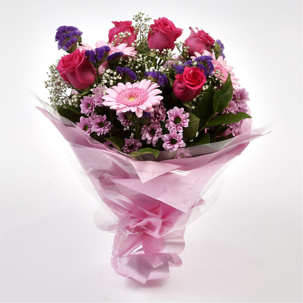 Pink Classic BouquetAn endearing classic in soft Pink with deep pink accents. Exquisite large headed Roses are complemented by Palm & delicate Pink Gypsophila, luxurious green foliage Pink Statice, to create a sophisticated hand-tied bouquet certain to im