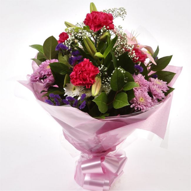 Stunning Pink Cerise BouquetThis Sweet Pink bouquet features matching Pink Chrysanthemums, Pink Cerise Carnations, purple Statice and Gypsophila, punctuated with leaves Pink Lillies, expertly created by our florists. Beautifully wrapped and tied with ribb