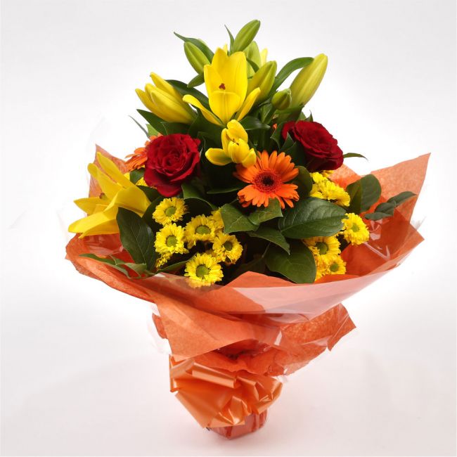 Orange Sunshine BouquetThis Sunshine bouquet features matching Red Roses.Orange Gerberas, Red Carnations, Lillie's with Solidago and other assorted flowers, punctuated with palm leaves expertly created by our florists.Beautifully wrapped and tied with rib