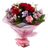 Pastel Beautiful BouquetAn eye-catching hand-tied bouquet including Freesias, Statice, Spray Chrysanthemums and large-headed Red Roses complemented by white & purple Freesias. finished with a cerise ribbon, this vivid selection of flowers will create a st