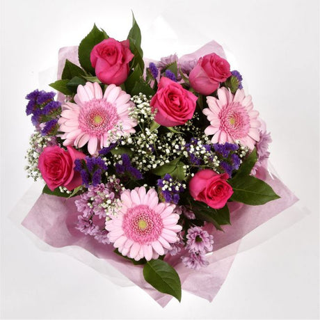 Pink Classic BouquetAn endearing classic in soft Pink with deep pink accents. Exquisite large headed Roses are complemented by Palm & delicate Pink Gypsophila, luxurious green foliage Pink Statice, to create a sophisticated hand-tied bouquet certain to im