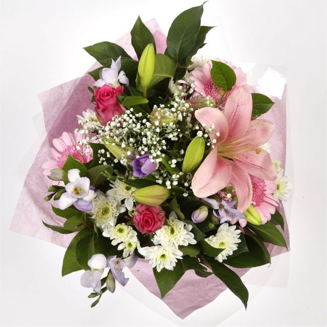 Pink Radiance BouquetAn endearing classic Lilies in soft pinks and whites with purple Freesias, large exquisite headed Anastasias, Pink Roses are complemented by delicate pink Gypsophila, luxurious sophisticated hand-tied bouquet certain to impress. Beaut